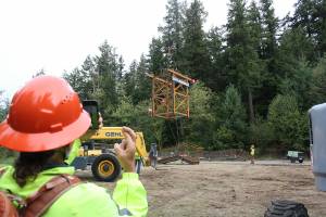 An observer on Mount Peak keeps his fingers crossed that the Chinook helicopter will be able to lift the framework of the fire lookout tower safety to the top of the mountain. Photo by Ray Miller-Still