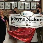 City Administrator Chris Searcy (right) and incoming Senior Center Manager Melissa Holt (center) present the plaque that will adorn the Enumclaw Senior Centers activity room, now named the Jobyna Nickum Activity Room. Nickum stands to the left. Photo by Alex Bruell