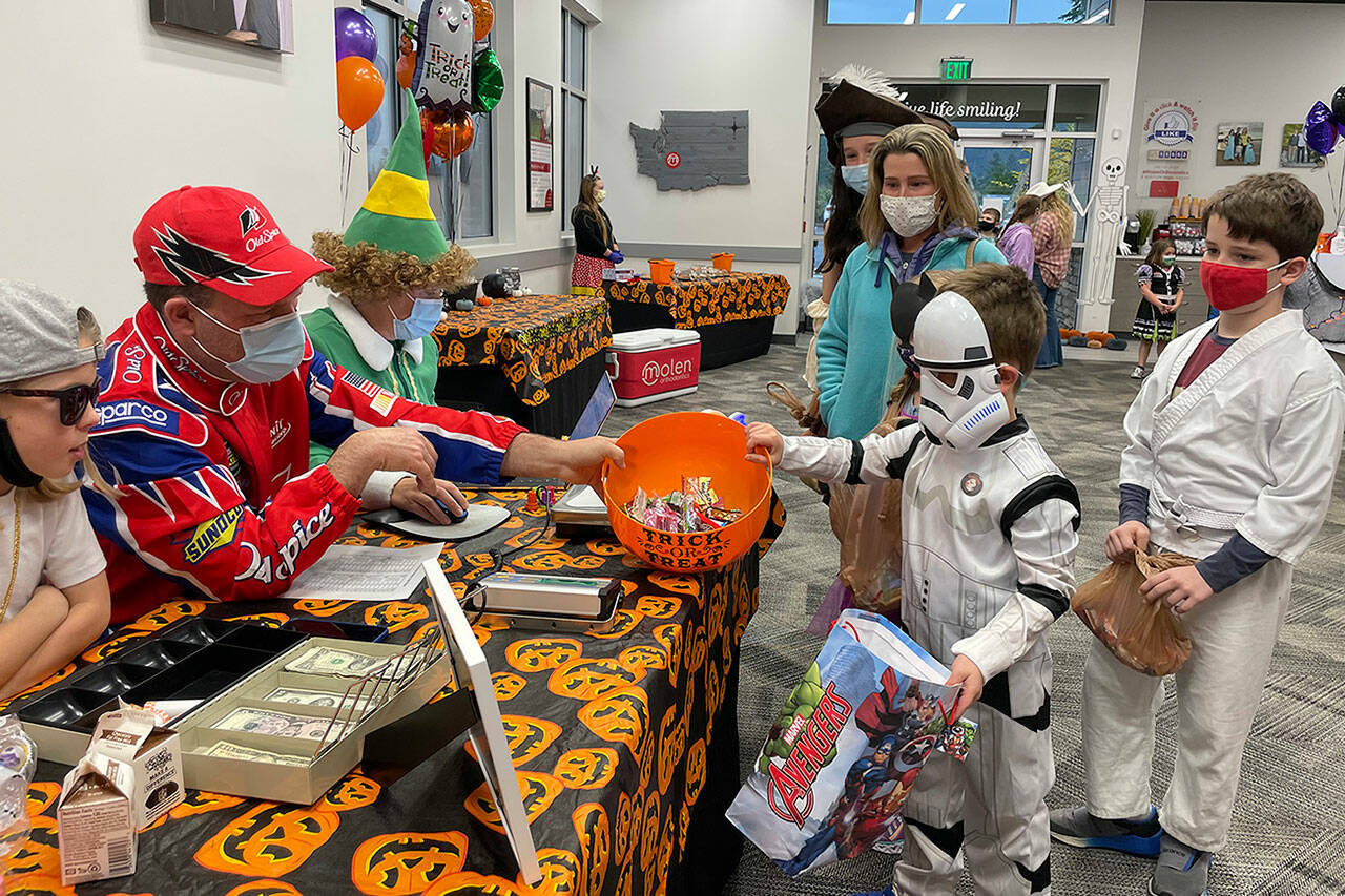 Dr. Rick Molen, left, weighing candy brought in by more than 482 participants in this year's candy buy-back at Molen Orthodontists. Courtesy photo