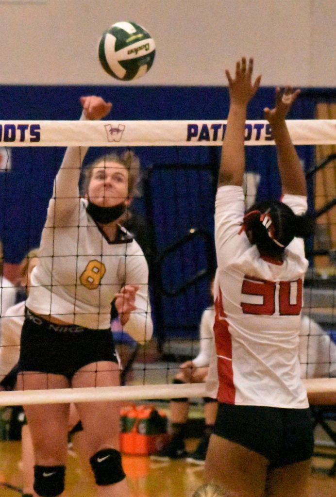 Enumclaw senior Rosie Penke registers a kill during the Hornets district victory over Sammamish. Guarding the net is the Redhawks Akshar Ameir.