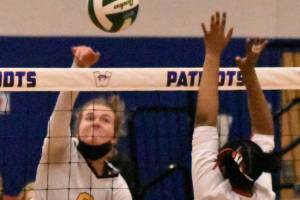 Enumclaw senior Rosie Penke registers a kill during the Hornets' district victory over Sammamish. Guarding the net is the Redhawks' Akshar Ameir. Photo by Kevin Hanson