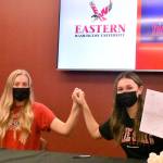 PHOTO BY KEVIN HANSON White Rivers Brooke Mahler (left) and Brooke Gelinas celebrate at the conclusion of a signing ceremony at their school. Each will be playing collegiate golf next year.