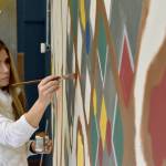 Jamie Ferguson, a local artist and owner of Ember Murals, works on finishing the large mural at the back of The Game Vault on Nov. 24, two days before the stores grand opening.