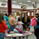 Students from Enumclaw High School and other local schools busily pack backpacks for Afghan refugees in the high schools common area during just after the end of the school day on Sept. 20. Photo by Alex Bruell
