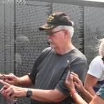 Daniel and Marie Hertlein look for names on The Moving Wall, specifically those who were a part of the 129th and 192nd assault helicopter companies. Photo by Alex Bruell