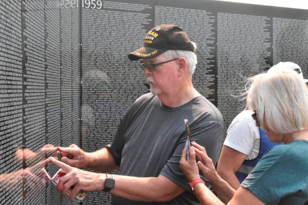 Daniel and Marie Hertlein look for names on The Moving Wall, specifically those who were a part of the 129th and 192nd assault helicopter companies. Photo by Alex Bruell