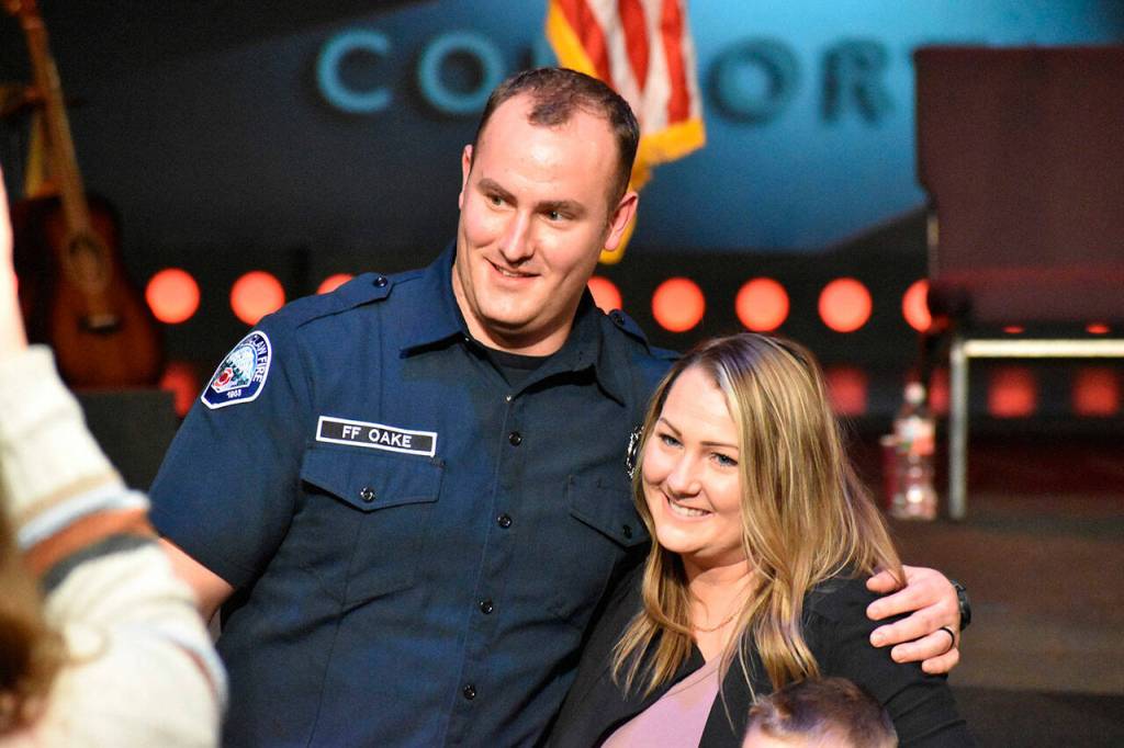 Mitchell Oake stands for pictures with his wife Kayla after she and their sons Hudson and Trace pin his new badge. Photo by Alex Bruell