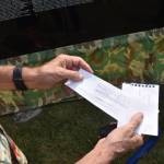 Bob Valentine holds a rubbing of the names of two people he knew who died in the Vietnam War.