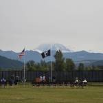 Mount Rainier rises behind The Moving Wall as its sits in a grassy field near Sunrise Elementary the afternoon of Thursday, Aug. 5. Photo by Alex Bruell.