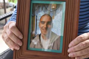 Karen Heide holds a framed photo of her son Austin Chase, who disappeared more than a year ago. Photo by Alex Bruell.