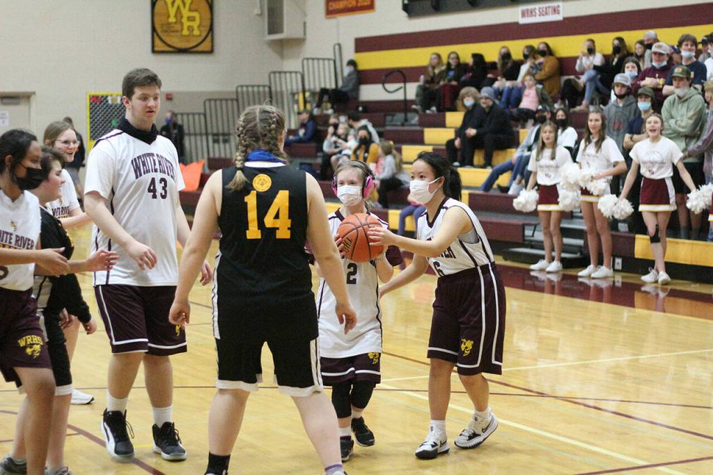 Partner Yuma Kato (6) handing the ball off to Mary Weymiller (2), who is eying the basket. Photo by Ray Miller-Still