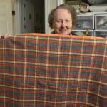 Naomi Allen shows one of her recently-finished quilts soon headed off for a senior who could use it. Photo by Alex Bruell