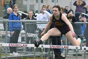 Enumclaw kicked off its Track and Field season in a drizzly afternoon bout with Fife on March 17. Ellie DeGroot, pictured here, clears a hurdle early on in the meet. Photo by Alex Bruell