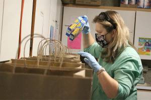 Fiona Drynan, a local volunteer, preparing some pre-packed meals for Enumclaw families needing food from the Enumclaw Food Bank back in 2020, when the pandemic was just getting started. Photo by Ray Miller-Still
