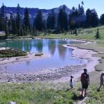 Hiking the Naches Peak Loop Trail begins and ends with the iconic view of Tipsoo Lake with Mount Rainier in the background. This photo shows a family enjoying a stop at a small alpine pond. Photo by Kevin Hanson