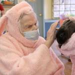Bonnie Dudley, who dressed up for Buckleys Heritage House holiday celebration, pets Blueberry the bunny. Photo by Ray Miller-Still