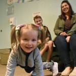 PHOTO BY ALEX BRUELL Isla Pringle, 2, is a bundle of energy at the Wabash Church while her brother Francis and mother Anna sit for a photo behind her.