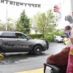 An Enumclaw Police Officer waves to Elma on her 106th birthday. Police and firefighters stopped by the assisted living community she lives at to wish her a happy birthday May 26, although the firefighters had to leave early to respond to a call for service. Photo by Alex Bruell