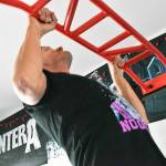 Butch Holman, running through his routine to prepare for The Murph challenge, does a few pullups in his at-home gym. Photo by Alex Bruell