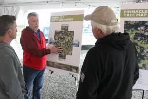 King County’s Community Partnerships and Grants Program manager Scott Thomas talks to a couple locals about the proposed tree cutting plan on Mt. Peak before the official presentation. Photo by Ray Miller-Still