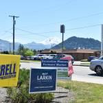 Political campaign signs, as well as a sign for the Enumclaw Plateau Farmer's Market, are posted along Highway 410 in Enumclaw on a hot July afternoon. Mount Rainier appears in the background. Photo by Alex Bruell.