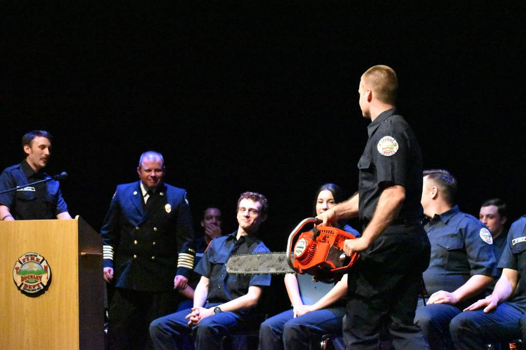 The recruits surprise Buckley Fire Chief Eric Skogen with a signed chainsaw.
