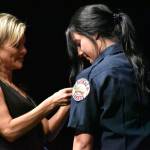 Graduating recruit Haley Armstrong has her badge pinned by her mother.