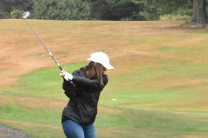 PHOTO BY KEVIN HANSON
The greens and fairways were turned crimson and gray on a Saturday morning in 2021 when the Enumclaw Golf Course played host to a tournament that raised money for the WSU wrestling program. Above, Heather McCann begins with a drive down the first fairway. She was one of 37 participants who helped generate $13,500 for the Cougar program that year. Aside from players, money came from 20 businesses and individual sponsors, an auction of 28 donated items and the sale of WSU wrestling T-shirts. Phil Burnett, who coaches the WSU team, is an Enumclaw resident.