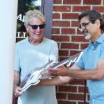 Mayor Jan Molinaro presents REO Speedwagon lead singer Kevin Cronin with a giant key to the city in the shape of an electric guitar. Photo by Alex Bruell.