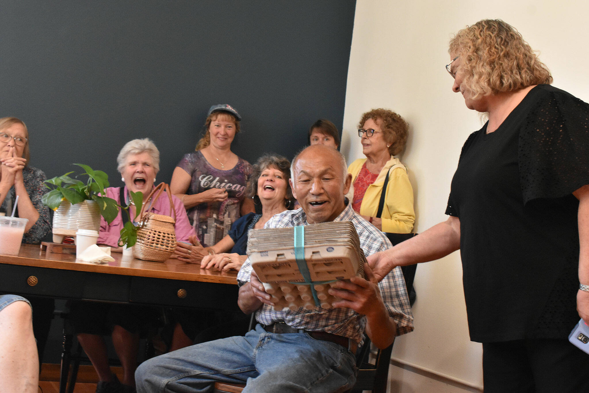 Photos by Alex Bruell 
Carl Lee is handed a gift by Food Bank Facility Manager Donna Garland.