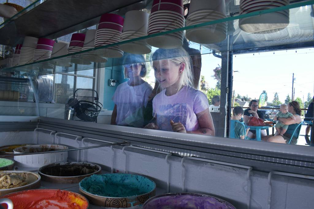 Brooklyn Olsen, left, and Reese Olsen peruse the ice cream flavors at The Scoop in Buckley. Photo by Alex Bruell.