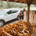 Taylor Larson helps a DoorDash driver load up his car with curated food boxes for customers. Photo courtesy The Market