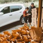 Taylor Larson helps a DoorDash driver load up his car with curated food boxes for customers. Photo courtesy The Market