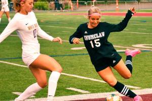 Enumclaw's Bella Baird winds up to clear the ball from her end of the field while being pressured by White River's Laura Corr. Photo by Kevin Hanson