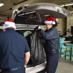 Photo by Alex Bruell 
Buckley firefighters load gifts into a familys vehicle during the Giving Tree Event last Saturday. Nearly 300 kids got big bags of presents.