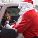 Photo by Alex Bruell 
Santa Claus - really Buckley Log Show President Jeff Fetter - helps Steffen Hintz pick out candy canes for his young ones at the fire station.