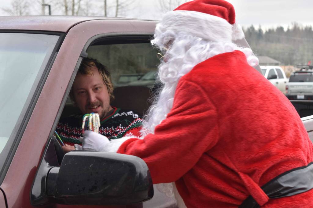 Photo by Alex Bruell 
Santa Claus - really Buckley Log Show President Jeff Fetter - helps Steffen Hintz pick out candy canes for his young ones at the fire station.