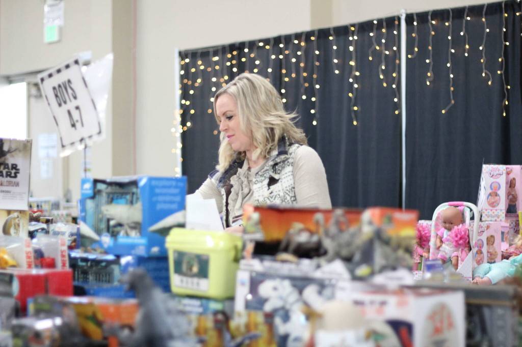 Photo by Ray Miller-Still 
The Enumclaw Expo Centers Les Schwab Hall was filled with all manners of toys, games, and books for all ages last weekend as Plateau Kids Network volunteers like Tanna Bunker, pictured, put together shopping bags for local families based on their kids gift likes and preferences.
