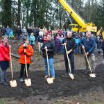 Foothills Rails to Trails Executive Director Shayla Miles, former Buckley Mayor Pat Johnson, former Enumclaw Mayor Liz Reynolds, King County Executive Dow Constantine, Pierce County Executive Bruce Dammeier, and King County Parks and Rec Director Warren Jimenez pose with their ceremonial shovels in front of the crowd gathered at the groundbreaking. Photo by Ray Miller-Still