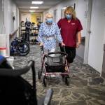 CNA Nina Prigodich, right, goes through restorative exercises with long term care patient Betty Long, 86, at View Ridge Care Center on Friday, in Everett. (Olivia Vanni / The Herald)