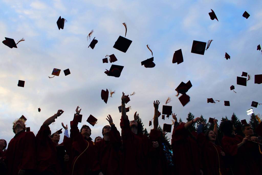 The graduates toss their caps at the close of the ceremony. Alex Bruell / Sound Publishing.