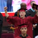 A student celebrates receiving his diploma. Alex Bruell / Sound Publishing.