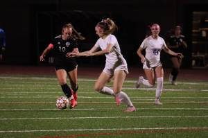 Senior, Anne Anderson, maneuvering away from defenders as she advances downfield. Photo by Andy Orozco