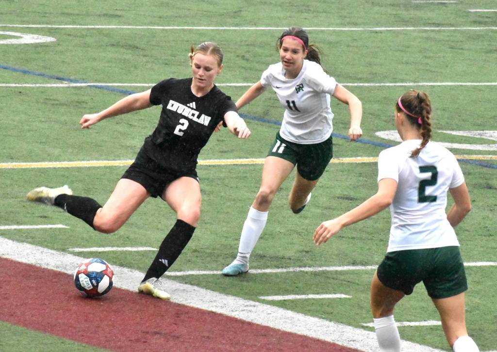 Photo by Kevin Hanson
Enumclaw junior Ally Mavin, under pressure from a pair of Roughriders, prepares to launch a pass downfield during Saturdays District 2/3 match at the Expo Center.