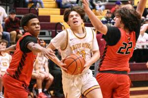 Photos by Kevin Hanson
The White River High basketball teams swept their Franklin Pierce guests Friday night. The Hornet girls opened the hoop doubleheader with a lopsided 65-17 victory and the boys followed with a 77-62 win. In this photos, White Rivers Logan Senon splits a pair of Cardinal defenders on his way to the hoop.