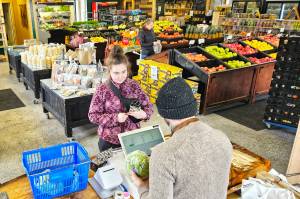 Photo by Ray Miller-Still
Rainier Fresh Country Stores owner, Patrick Brown, checking out a customer last Friday.