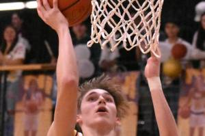 Photo by Kevin Hanson
White Rivers Ben Berg goes high for an uncontested bucket during Thursday nights victory over Enumclaw High.