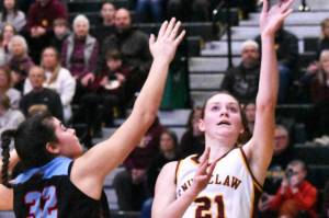 EHS' Bella Firnkoess (21) goes up for two points despite pressure from the Monarchs' Natalie Mejia. Photo by Kevin Hanson