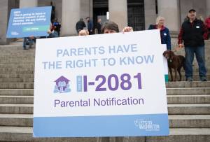 Photo by Mary Murphy
Demonstrators carry signs calling for passage of a parental notification initiative during a protest in Olympia. The initiative was approved by the Legislature.