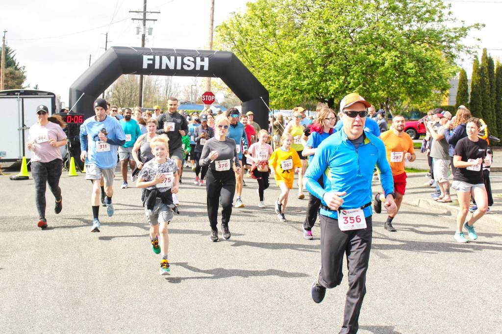 More than 200 runners showed up at the Enumclaw Chamber of Commerce's second-annual Rainier Run 5K last Saturday, and even more just stuck around for the block party, which featured Renaissance Fair characters, food trucks, a beer garden, and more. Pictured breaking away from the group in the Kiddie Dash before the big race is Sienn Carvantes, who also placed second in her age group in the 5K; and Sizzle the Clown putting the finishing touches on a unicorn for Mila Wright. Photos by Ray Miller-Still